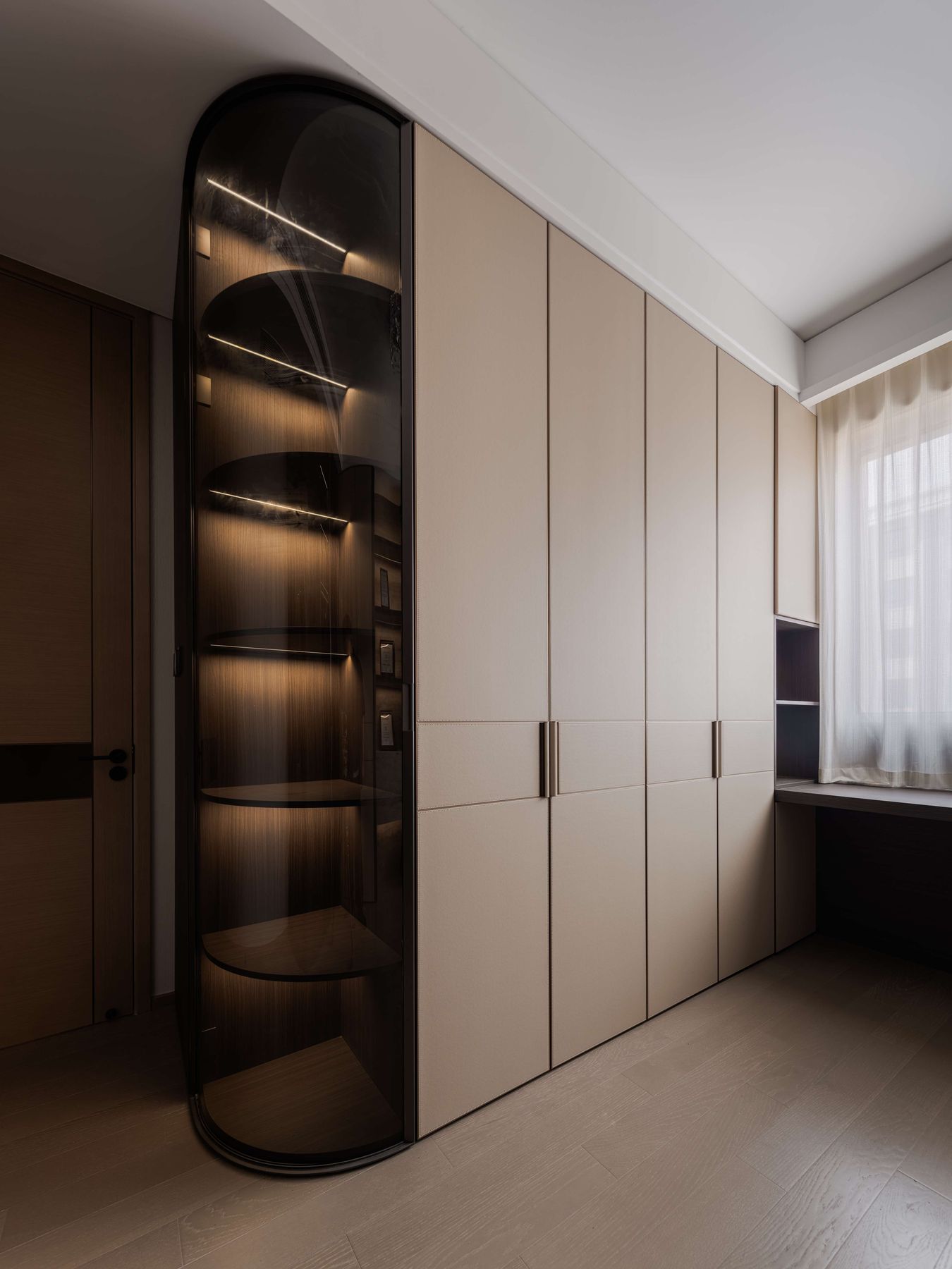 Curved smoked-glass display column with LED-lit shelves