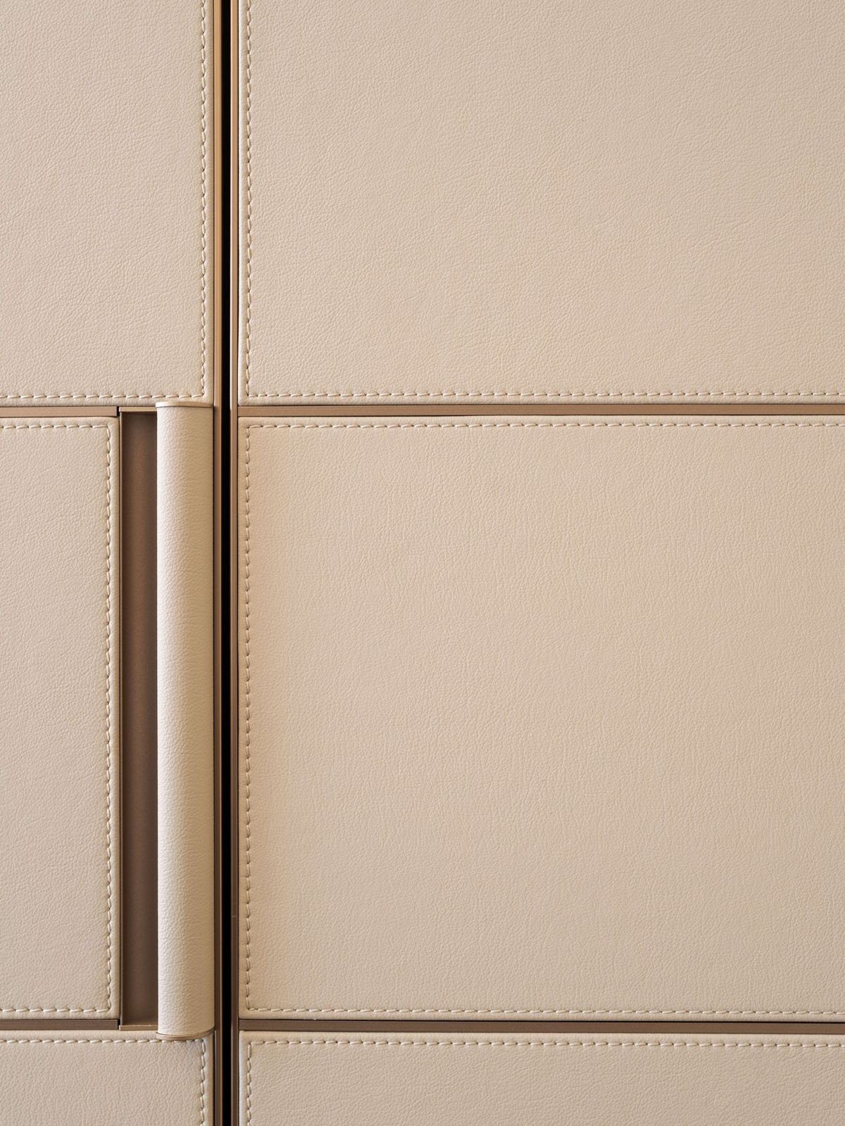 Close-up of stitched faux leather door and wrapped pull handle