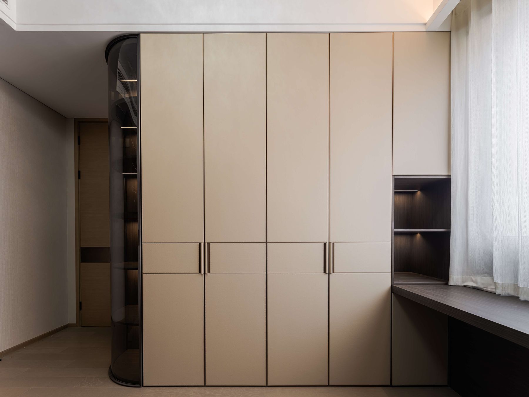Wall of faux leather wardrobe doors beside a curved glass display