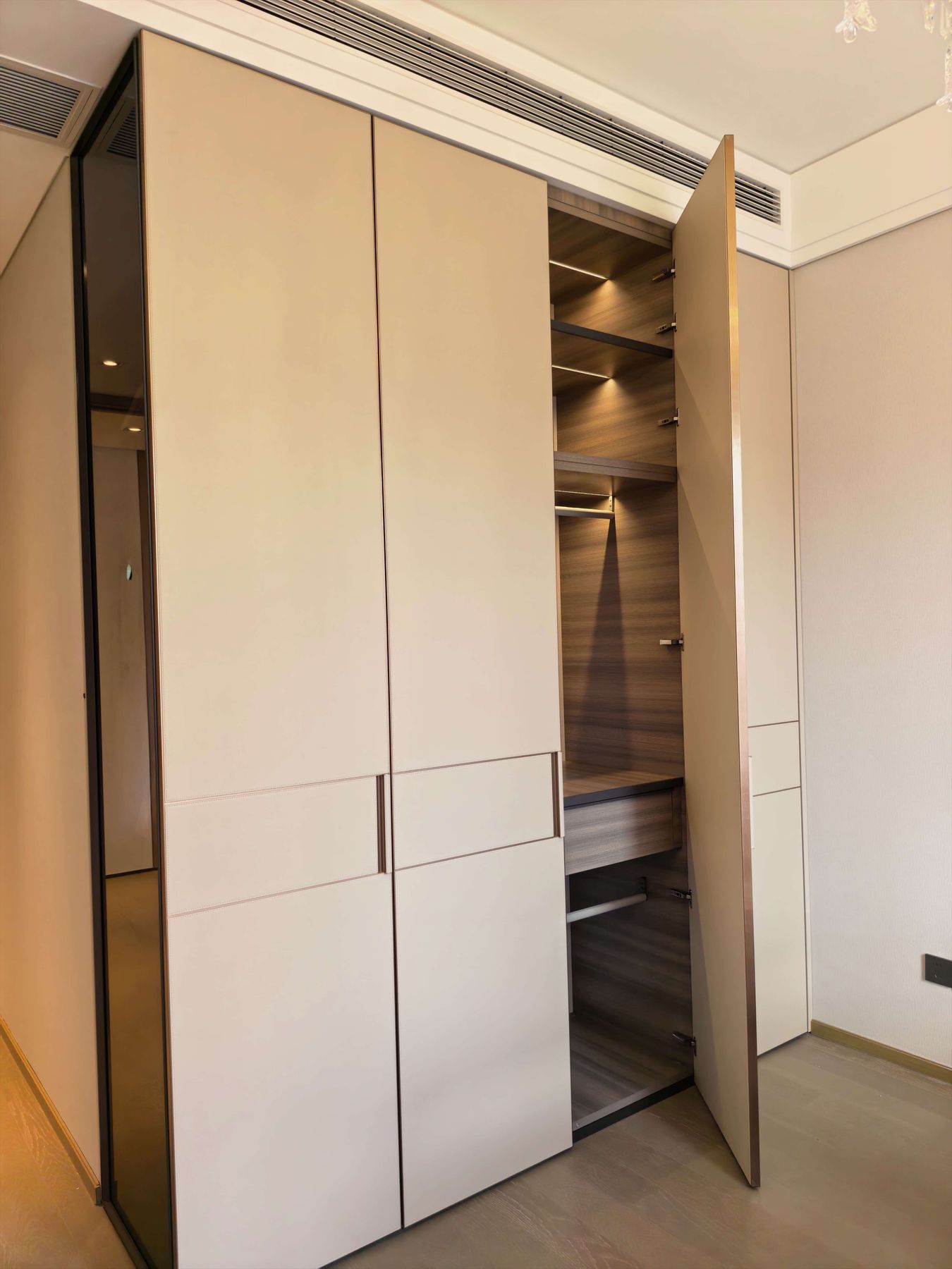 Open wardrobe showing LED-lit shelves, hanging rail and drawer