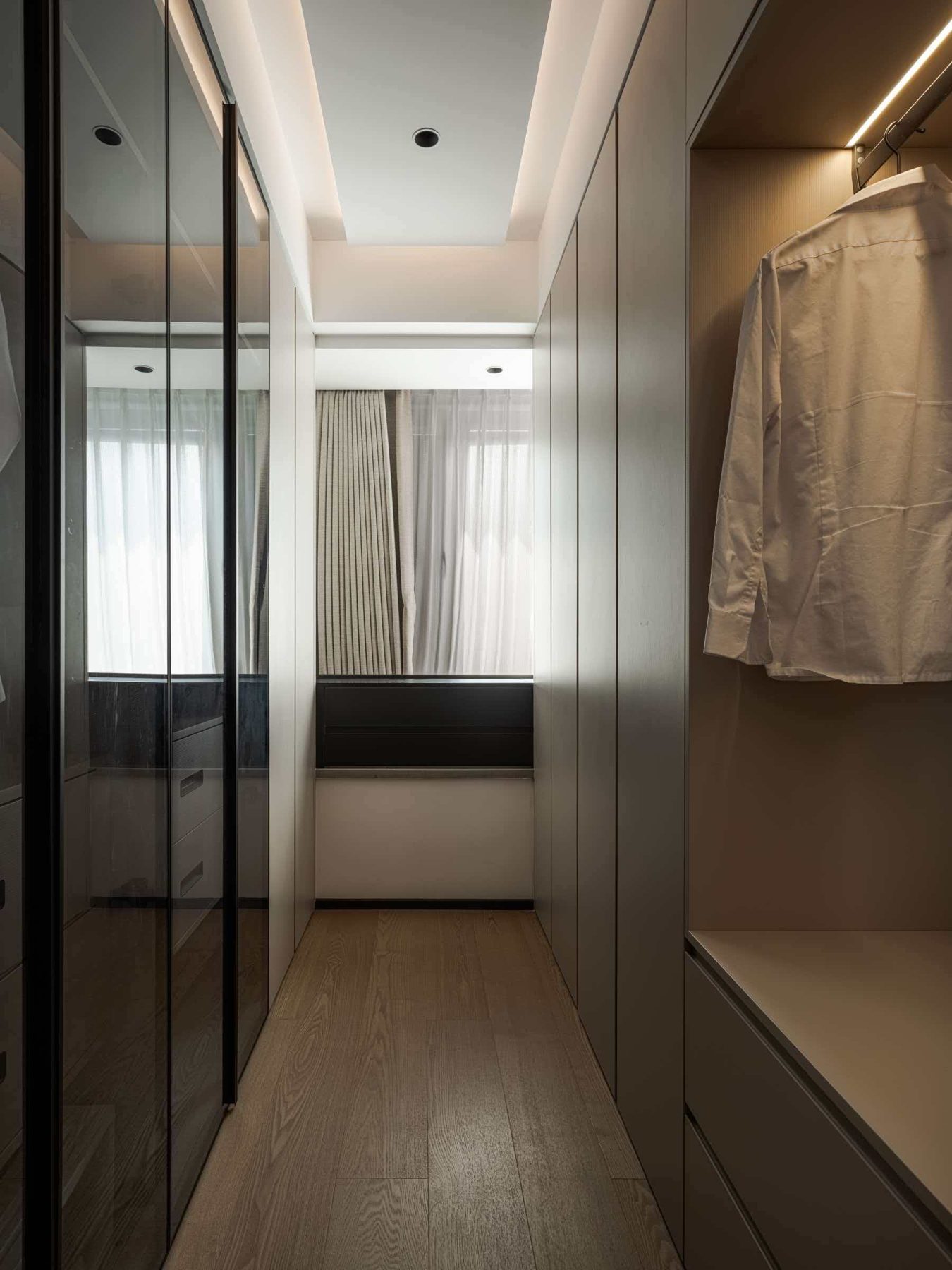 Walk-in wardrobe corridor with smoked glass doors