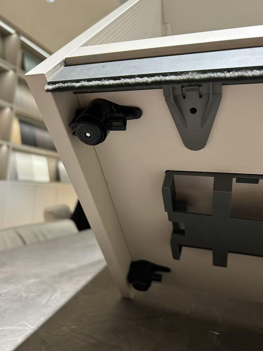 Underside of a cabinet base with levelling feet and a power box
